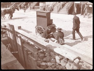 View of a Street Organist and a Woman Eating Lunch on West 42nd Street, New York, 1898